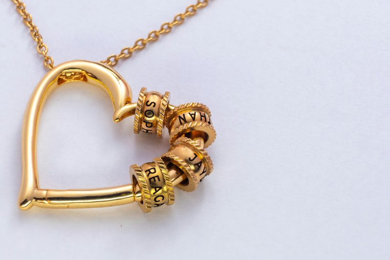 Pingente de coração dourado com berloques
